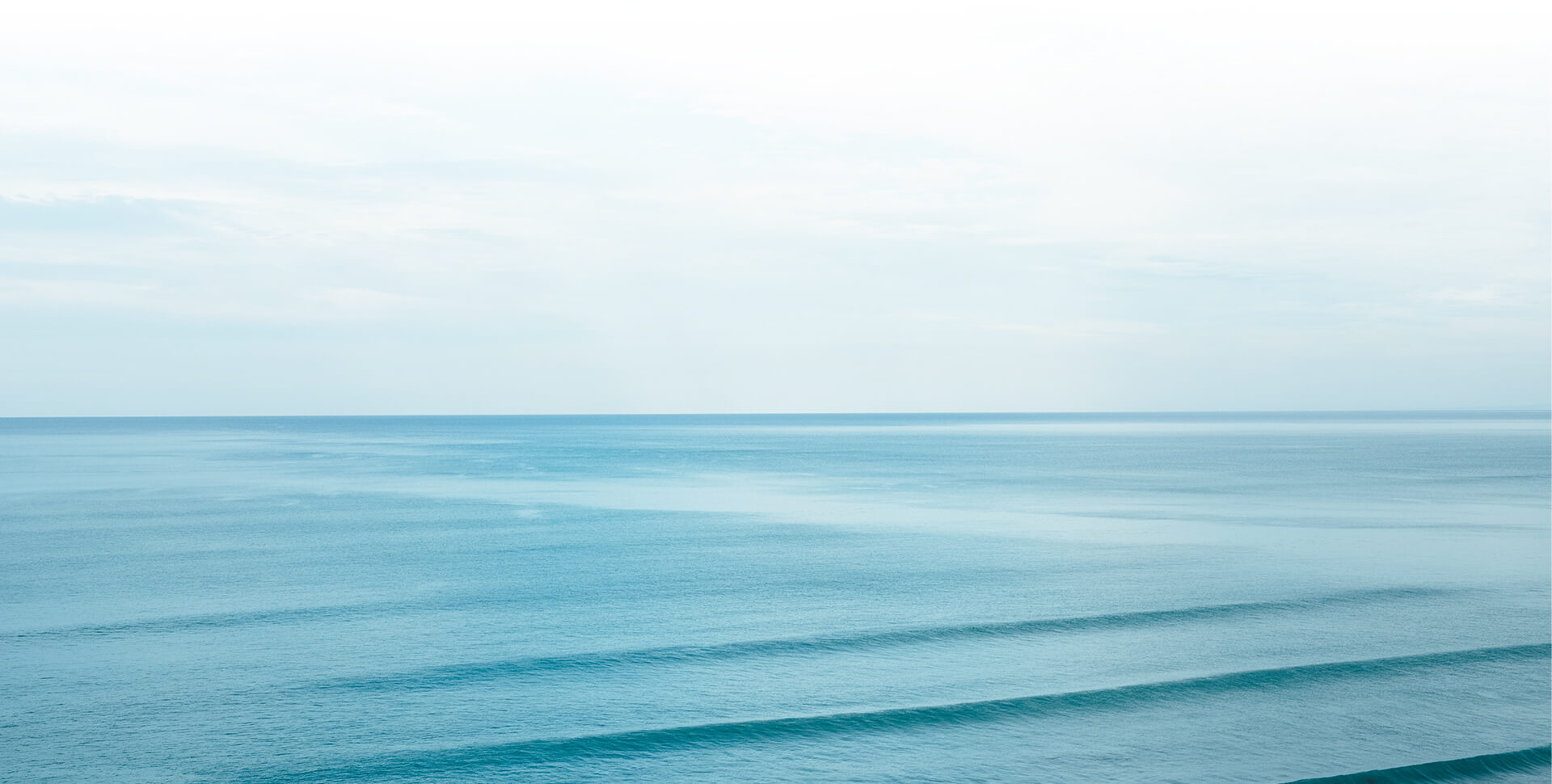 A blue ocean with waves in the distance.